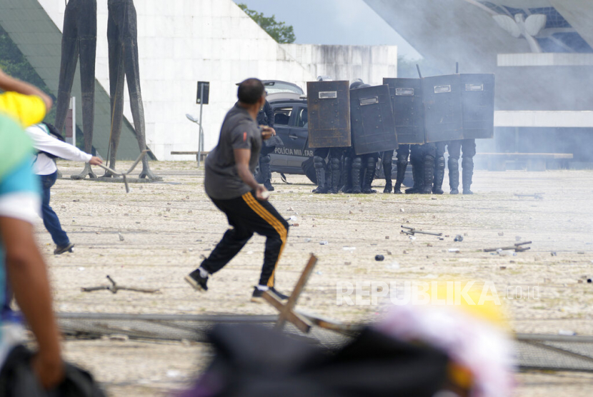Pendukung mantan presiden Brasil Jair Bolsonaro bentrok dengan polisi saat menyerbu Istana Planalto di Brasilia, Brasil, Ahad, 8 Januari 2023. 