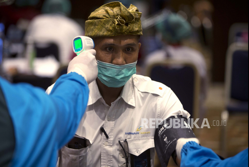 Seorang pria menjalani pemeriksaan medis sebelum menerima suntikan vaksin COVID-19 Sinovac saat vaksinasi massal untuk orang-orang yang bekerja di industri pariwisata dan transportasi di Nusa Dua, Bali, Indonesia pada Kamis, 4 Maret 2021.