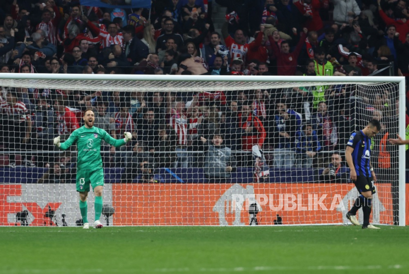 Kiper Atletico Jan Oblack (kiri) merayakan setelah pemain Inter Lautaro Martinez (kanan) gagal mengeksekusi tendangan penalti definitif pada pertandingan sepak bola leg kedua babak 16 besar Liga Champions UEFA antara Atletico de Madrid dan FC Inter, di Madrid, Spanyol, Kamis (14/3/2024) dini hari WIB.