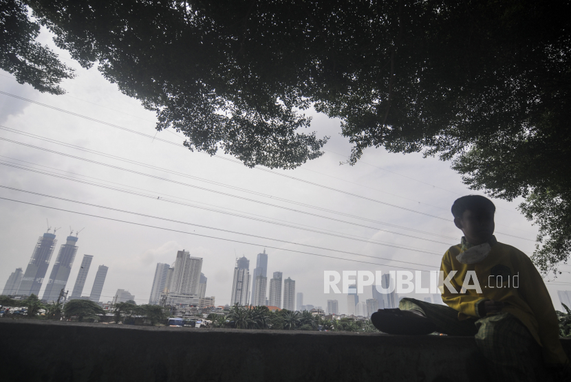 Anak-anak duduk dengan latar belakang gedung bertingkat yang diselimuti kabut polusi di Jakarta, Jumat (1/4/2022). Berdasarkan situs IQAi, indeks kualitas udara di Jakarta berada di level 114 AQI US dengan particulate matter (PM) 2,5 dan berada di urutan kota urutan ke-10 dengan kualitas udara terburuk di dunia pada hari ini. Polusi Bunuh Sembilan Juta Orang di Dunia Setiap Tahun