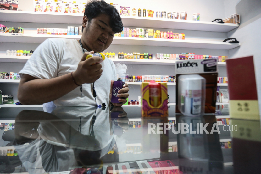 Penjual meneteskan cairan pada rokok elektrik di salah satu toko di Pekayon, Jakarta Timur, Selasa (27/12/2022). Pemerintah memutuskan kebijakan kenaikan tarif cukai hasil tembakau (CHT) per 1 Januari 2023 untuk jenis rokok elektrik rata-rata 15 persen per tahun dan hasil pengolahan tembakau lainnya (HPTL) rata-rata 6 persen per tahun hanya berlaku dua tahun atau 2023 dan 2024 yang sebelumnya pemerintah menetapkan kenaikan untuk keduanya berlaku lima tahun sekaligus. 