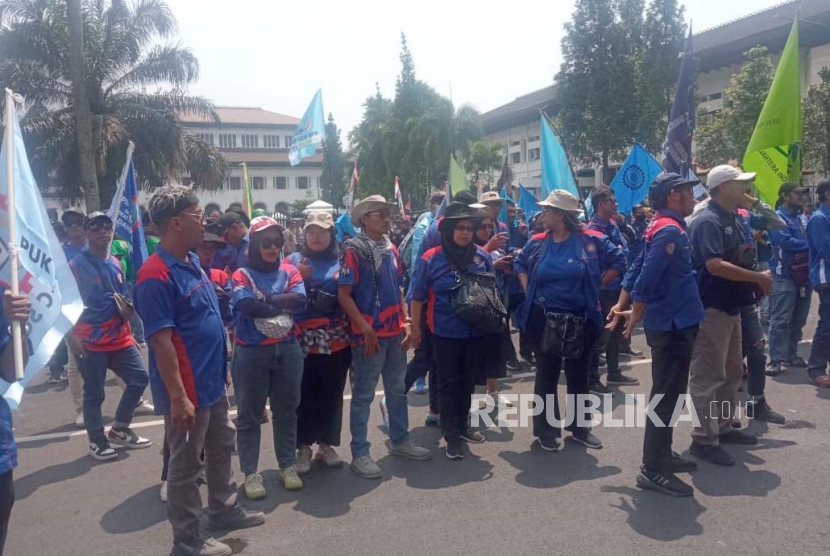 Massa buruh menggelar aksi unjuk rasa di depan Gedung Sate, Kota Bandung, Kamis (14/12/2023), untuk menuntut revisi keputusan penetapan UMK 2024.