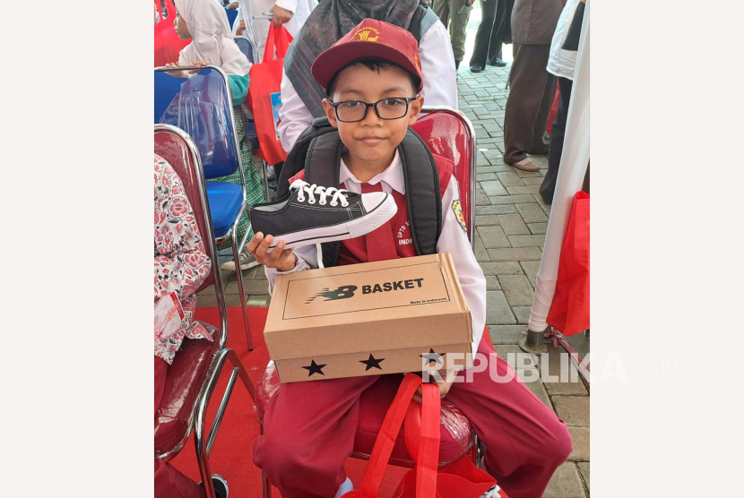 Muhammad Roji Nurfajri (9) siswa kelas tiga SDN 3 Margadadi Kabupaten Indramayu menerima bantuan sepatu baru, Rabu (3/4/2024). 