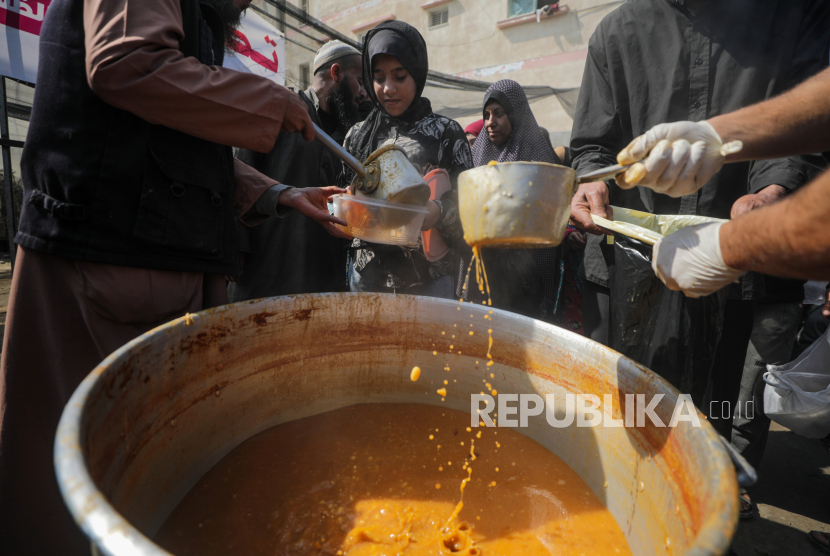 Pengungsi Palestina menerima makanan yang disediakan oleh relawan di kota Deir Al Balah, Jalur Gaza Selatan, Sabtu (24/2/2024). Sebanyak 1,9 juta orang telah mengungsi di Gaza akibat konflik berkepanjangan. Badan Bantuan dan Pekerjaan PBB untuk Pengungsi Palestina (UNRWA) menyatakan sebagian besar warga sipil di Gaza sangat membutuhkan bantuan kemanusiaan.