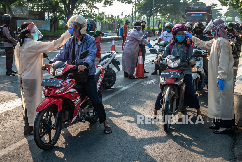 Petugas memeriksa suhu tubuh pengendara sepeda motor di pos pantau perbatasan Kabupaten Demak - Kota Semarang, di Semarang, Jawa Tengah, Rabu (6/5/2020). Sejak pemberlakuan Pembatasan Kegiatan Masyarakat (PKM) oleh Pemkot Semarang pada Senin (27/4/2020) lalu, sebanyak 16 pos pantau disiagakan untuk memeriksa kesehatan serta keperluan pengendara sepeda motor maupun mobil bernomor polisi luar kota yang akan memasuki Kota Semarang, guna mencegah penyebaran wabah COVID-19