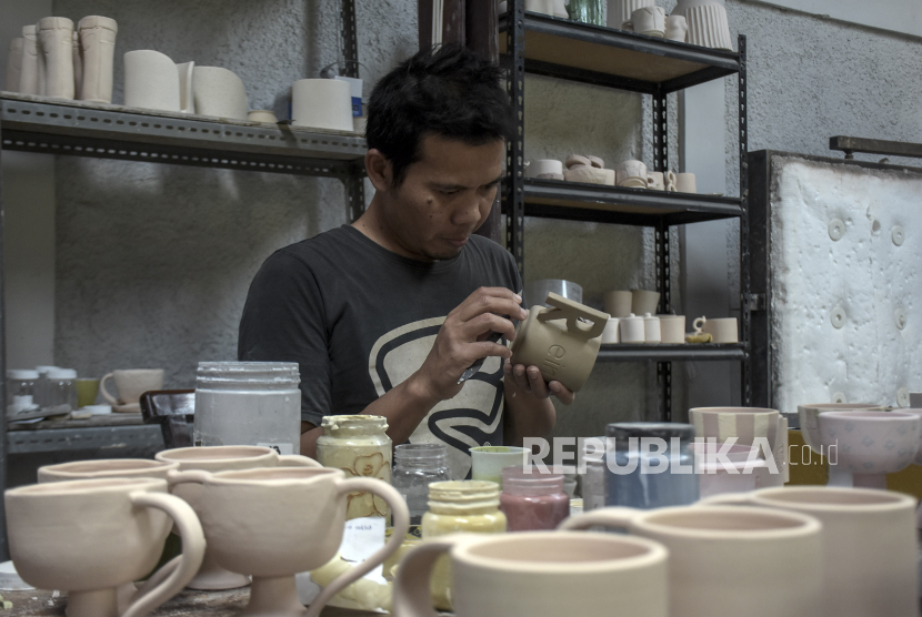 Pekerja menyelesaikan pembuatan gelas keramik di Elina Keramik, Jalan Taman Pramuka, Bandung Wetan, Kota Bandung, Provinsi Jawa Barat, Sabtu (18/2/2023). Berbagai jenis kerajinan keramik seperti mangkuk, gelas, aksesoris, cinderamata dan dekorasi rumah yang dijual dengan harga Rp10 ribu hingga Rp3,5 juta tersebut telah menembus pasar ekspor di Singapura, Belanda dan Uni Emirat Arab.
