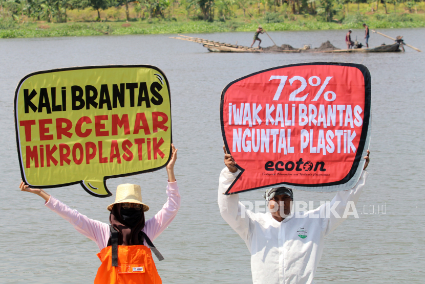 Aktivis lingkungan hidup dari Ecological Observation and Wetlands Conservation (Ecoton) membentangkan poster saat aksi tolak pencemaran sungai Brantas di Kota Kediri, Jawa Timur, Ahad (12/7/2020). Tim peneliti Ecoton menemukan sejumlah polutan berbahaya di sungai terpanjang ke dua di pulau Jawa tersebut di antaranya kandungan mikroplastik yang dapat merusak ekosistem dan berbahaya bagi kesehatan manusia. 