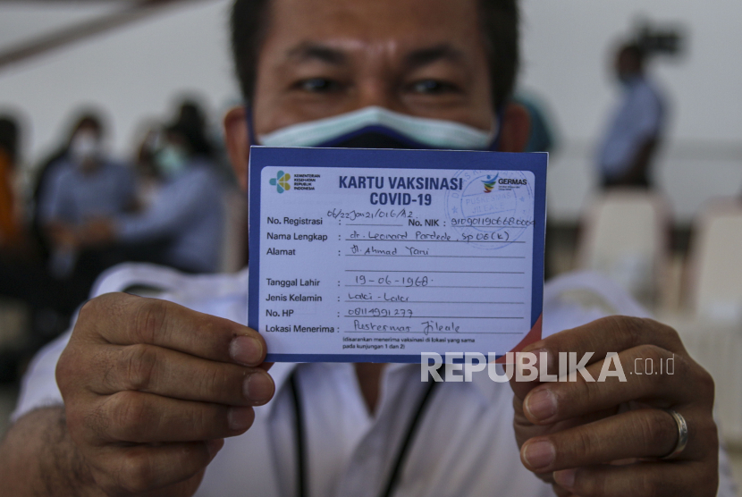 Ketua Ikatan Dokter Indonesia (IDI) Cabang Mimika dr. Leonard Pardede menunjukkan kartu vaksinasi usai menerima vaksin COVID-19 Sinovac di Kabupaten Mimika, Papua, Jumat (22/1/2021). Kabupaten Mimika saat ini menerima sebanyak 2.449 dosis vaksin Sinovac setelah Kabupaten Jayapura 1.343 dosis, dan kota Jayapura 3.464 dosis.