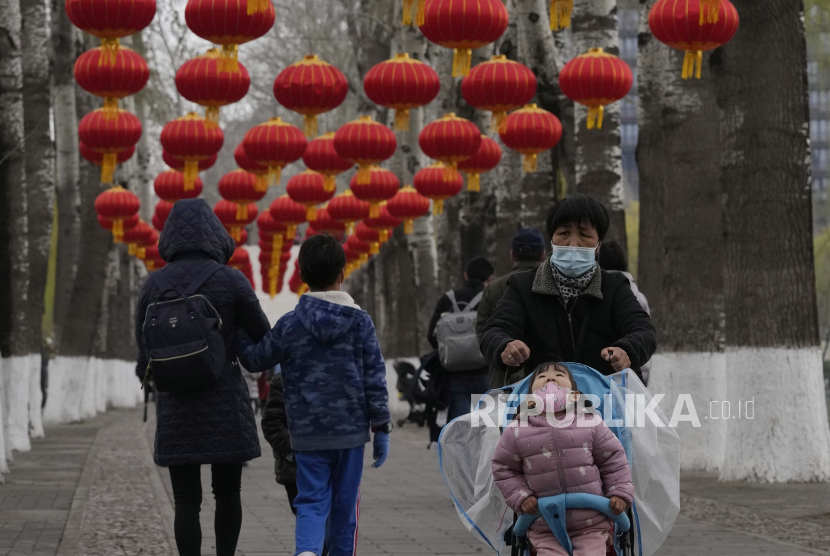 Seorang anak yang memakai masker bereaksi saat berkunjung ke taman pada Rabu, 30 Maret 2022, di Beijing, China. Melalui aturan terbaru, China melarang anak di bawah umur untuk mendapatkan tato meskipun orang tuanya memberikan izin.