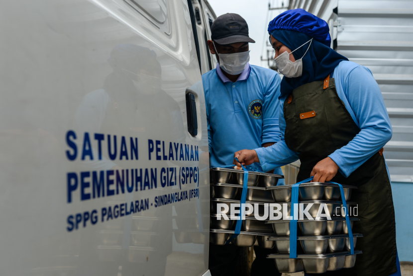 Petugas memasukkan makan bergizi gratis (MBG) ke dalam mobil untuk didistribusikan ke sekolah di SPPG Sindanglaya, Pandeglang, Banten, Selasa (9/9/2025). BGN Bantah isu penemuan SPPG fiktif.