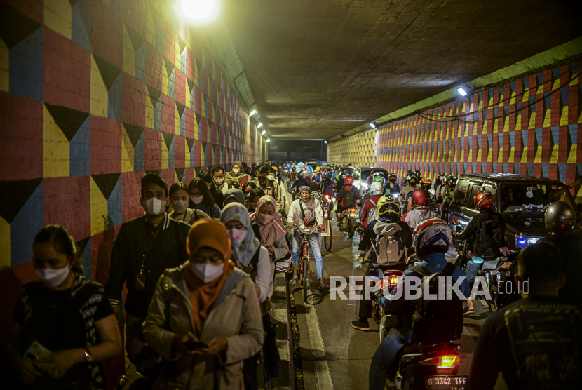 Sejumlah penumpang KRL Commuter Line mengantre untuk memasuki Stasiun Cawang, Jakarta, Kamis (23/12). Dampak dari pembatasan kuota penumpang yang akan menaiki KRL membuat terjadinya antrean penumpang di depan Stasiun Cawang hingga terowongan Cikokol. Republika/Putra M. Akbar