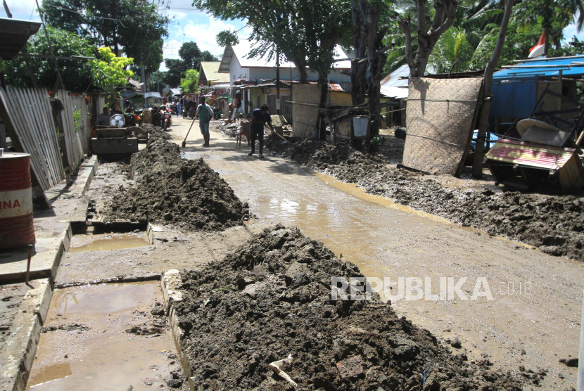 Warga membersihkan endapan lumpur di sejumlah ruas jalan pascabanjir di Kelurahan Bugis, Kota Gorontalo, Gorontalo, Senin (6/7/2020). Banjir yang terjadi akibat meluapnya Sungai Bone tersebut merendam ribuan rumah di lima kecamatan di daerah itu. 