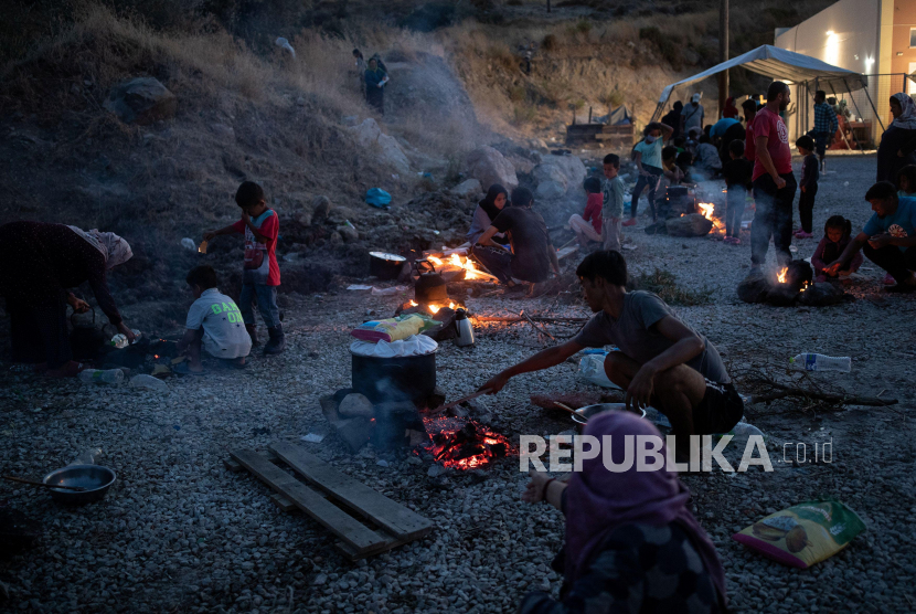 Pengungsi kamp Moria memasak di atas api di tempat penampungan mereka yang baru di pulau Lesbos, Yunani, 15 September 2020. 