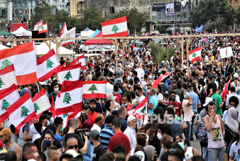 Rakyat Lebanon memegang plakat selama protes setelah ledakan, di Beirut, Lebanon, 08 Agustus 2020. Orang-orang berkumpul untuk melakukan apa yang disebut 