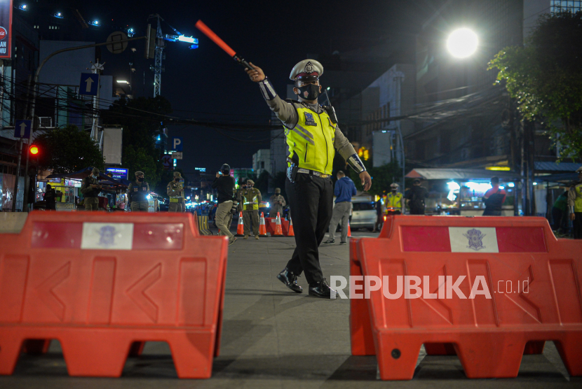 Aparat kepolisian melakukan penyekatan lalu linta di sejumlah wilayah DKI Jakarta dalam rangka pelaksanaan Pemberlakuan Pembatasan Kegiatan Masyarakat (PPKM) Level 4. Berdasarkan Twitter TMC Polda Metro Jaya yang terpantau, di Jakarta, Selasa (3/8) malam, petugas kepolisian melakukan penyekatan di wilayah Jakarta Timur dan Jakarta Selatan. (Foto: Petugas Kepolisian mengatur lalu lintas saat penyekatan)