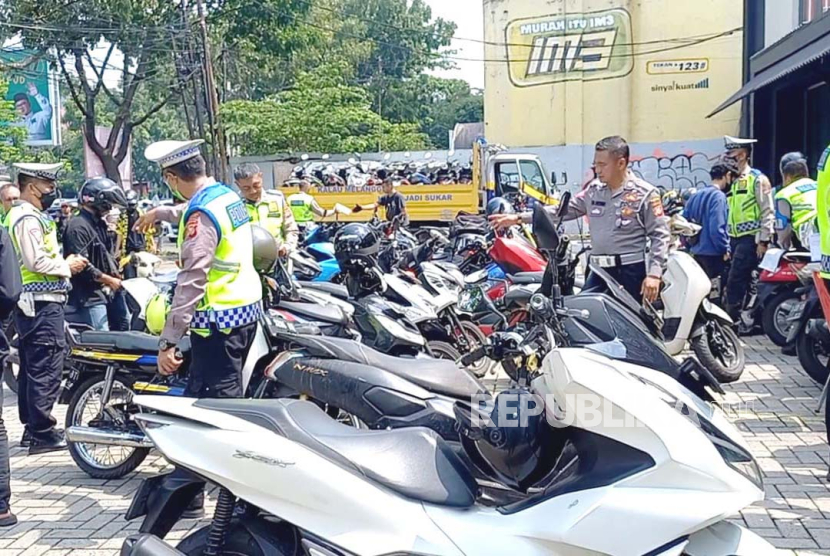 Ratusan pengendara motor yang menggunakan knalpot bising dirazia di Jalan Buahbatu, Kota Bandung, Rabu (10/1/2024). Para pengendara motor ditilang dan kendaraannya dibawa ke Mapolrestabes Bandung. 