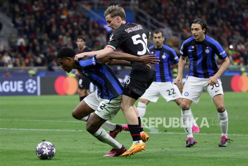 Pemain Inter Milan Denzel Dumfries (kiri) mongering bola menghindari Alexis Saelemaekers dari AC Milan saat pertandingan sepak bola leg pertama semifinal Liga Champions UEFA antara AC Milan dan FC Inter, di Milan, Italia, (10/5/2023).