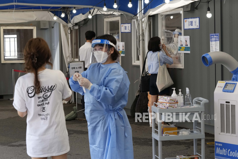 Petugas medis mengambil sampel hidung dari warga untuk tes virus corona di tempat pengujian darurat di Seoul, Korea Selatan.