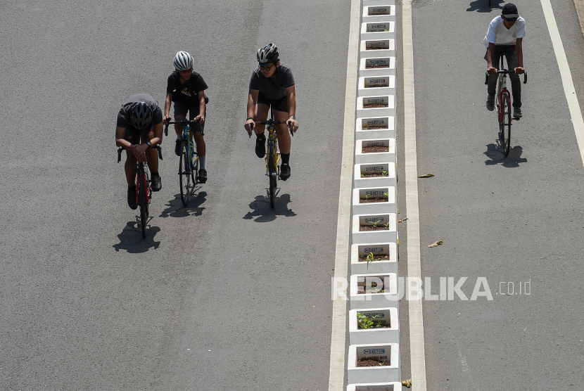 Pesepeda berada di luar jalur sepeda saat melintas di kawasan Sudirman Thamrin, Jakarta, Ahad (30/5). 