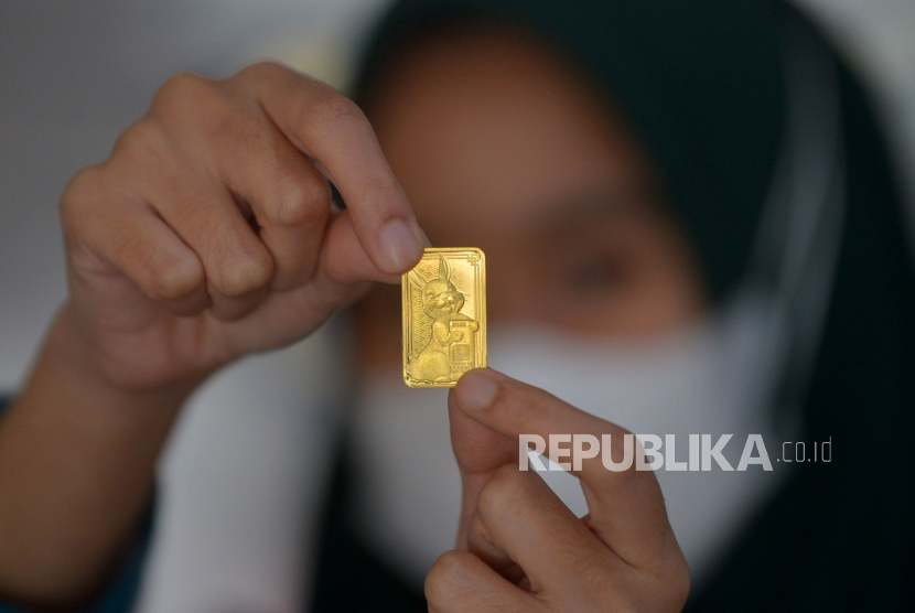 Petugas menunjukan emas batangan edisi imlek 2023 di Butik Emas Antam, Pulogadung , Jakarta, Senin (16/1/2023). Harga emas merosot pada akhir perdagangan Selasa (21/3/2023), karena investor mengambil untung setelah emas diperdagangkan pada level teknis tinggi baru-baru ini.