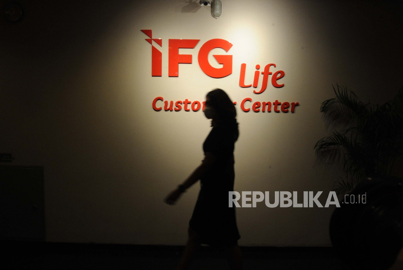 Pekerja melintas di depan layanan Customer Service IFG Life di Jakarta.