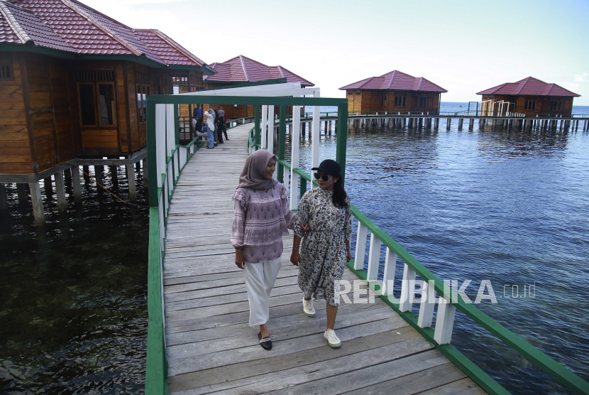Dua pengunjung melintasi dermaga vila terapung di objek wisata Pulau Nusa Ra di Pulau Bacan, Kabupaten Halmahera Selatan, Maluku Utara, Sabtu (20/4/2024). 