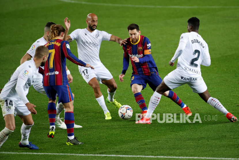  Striker FC Barcelona Leo Messi (2-R) bersaing memperebutkan bola dengan gelandang Huesca Mikel Rico (3-R) dan Idrissa Doumbia (kanan) selama pertandingan sepak bola Liga Spanyol antara FC Barcelona dan SD Huesca yang diadakan di stadion Camp Nou, di Barcelona , Catalonia, Spanyol, 15 Maret 2021.