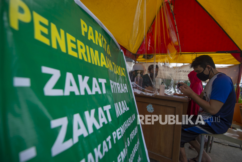 Warga menunaikan pembayaran zakat fitrah di Masjid Nurul Huda, Kebagusan, Jakarta.