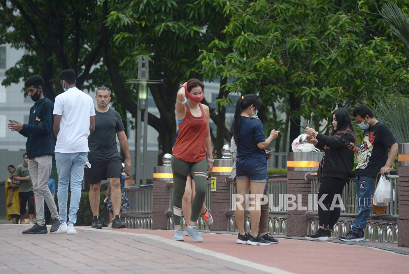 Sejumlah warga berolah raga di taman kawasan Menara Berkembar Petronas (KLCC) di Kuala Lumpur, Malaysia, Senin (7/9/2020). 