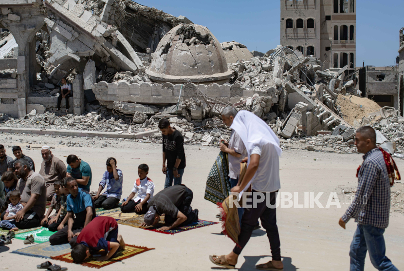 Pengungsi Palestina melaksanakan salat Jumat di samping reruntuhan Masjid Al-Islam, yang sebelumnya hancur akibat serangan udara Israel, di Khan Yunis, Jalur Gaza selatan, (24/5/2024).