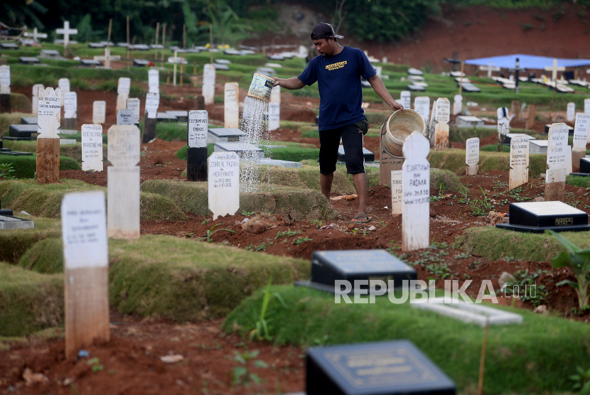 Pekerja melakukan perawantan di lokasi pemakaman jenazah dengan protokol Covid-19 di TPU Pondok Ranggon, Jakarta Timur.