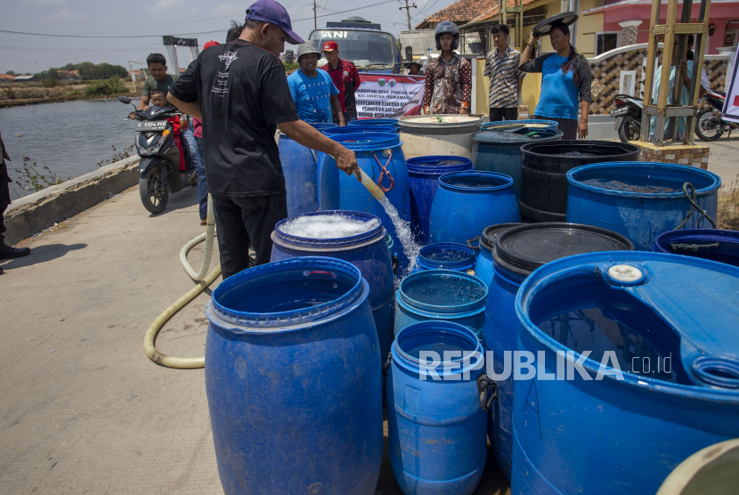 Warga antre untuk mendapatkan air bersih saat distribusi air bersih di desa Pabean udik, Indramayu, Jawa Barat, Kamis (19/10/2023). 