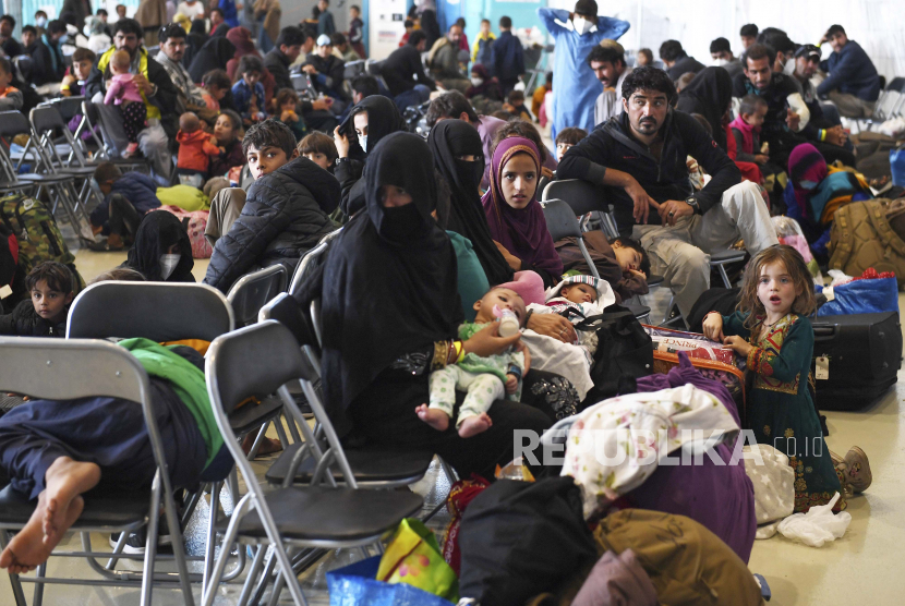 Pengungsi Afghanistan duduk saat mereka sedang diproses di dalam Hangar 5 di Pangkalan Udara Ramstein di Jerman, Rabu, 8 September 2021.