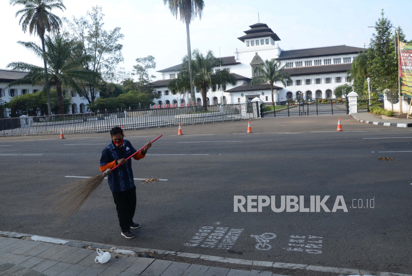 Petugas kebersihan menyapu jalan depan Gedung Sate, Jalan Diponegoro, Kota Bandung. Hingga 9 Juni Gedung Sate ditutup sementara setelah temuan 32 ASN Gedung Sate positif Covid-19.