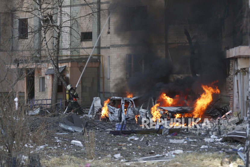  Petugas pemadam kebakaran dan tim keamanan Ukraina di lokasi sebuah gedung yang terkena rudal Rusia di Kyiv (Kiev), Ukraina, 20 Maret 2022.