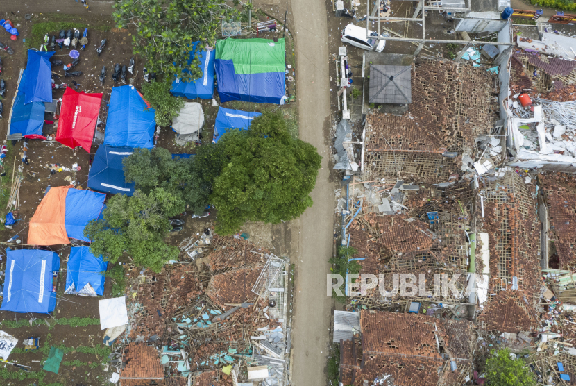 Sejumlah posko pengungsian warga berdiri di dekat rumah yang hancur akibat gempa bumi di Garogol Kidul, Cibulakan, Cugenang, Kabupaten Cianjur, Jawa Barat, Jumat (25/11/2022). Masa tanggap darurat penanganan gempa bumi di Kabupaten Cianjur ditetapkan selama 30 hari sejak Senin (21/11/2022). 