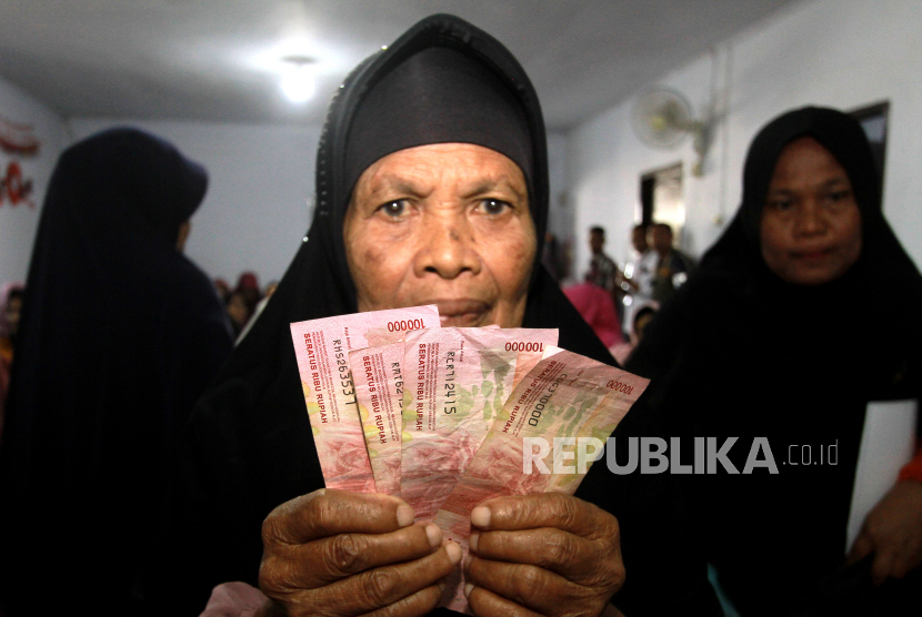 Warga menunjukkan uang bantuan langsung tunai (BLT) El Nino di Desa Dutohe, Kabupaten Bone Bolango, Gorontalo, Rabu (27/12/2023). Pada Februari 2024 masyarakat akan kembali menerima BLT.