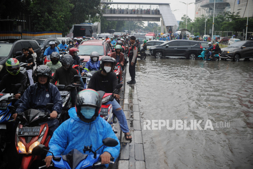 Sejumlah kendaraan menghindari genangan air di Jalan Raya Tanjung Barat, Jakarta.