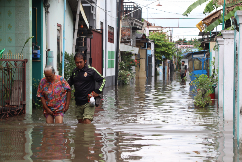 Warga melintas di jalan yang tergenang banjir (ilustrasi)