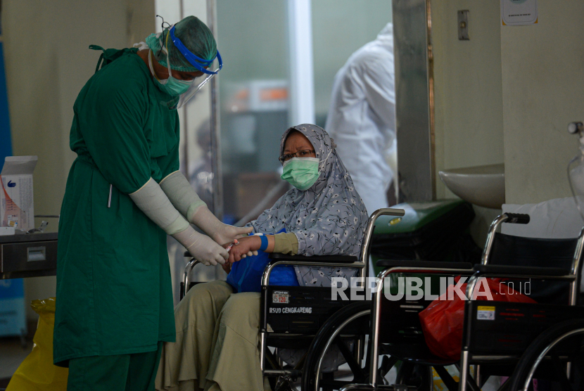 Petugas medis melakukan perawatan kepada pasien Covid-19 di selasar IGD RSUD Cengkareng, Jakarta Barat, Rabu (23/6). Peningkatan kasus harian Covid-19 di DKI Jakarta beberapa hari terakhir mengakibatkan keterisian tempat tidur di rumah sakit penuh sehingga perawatan pasien Covid-19 dalam keadaan darurat terpaksa dilakukan di selasar ruang IGD. Republika/Thoudy Badai