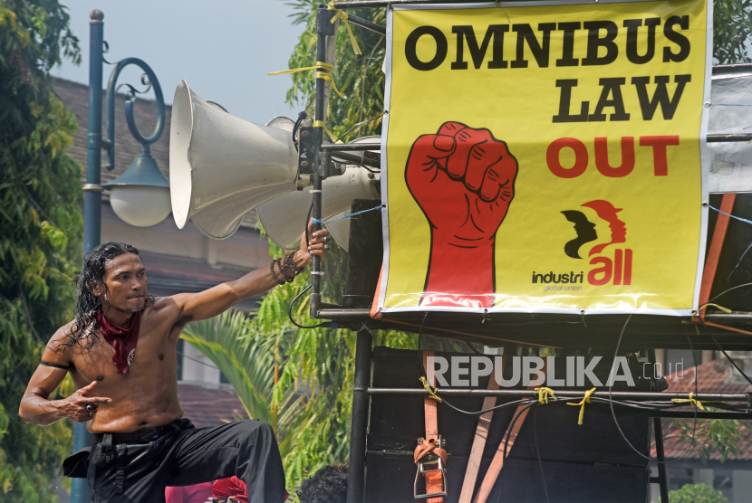 Seorang demonstran yang tergabung dalam Konfederasi Serikat Buruh Sejahtera Indonesia (KSBSI) berunjuk rasa menolak Omnibus Law Undang-undang Cipta Kerja.
