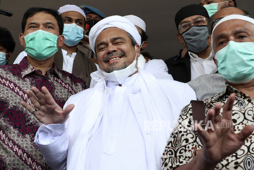  Ulama Indonesia dan pemimpin Front Pembela Islam Rizieq Shihab, tengah, melambai pada wartawan setibanya di Mabes Polri di Jakarta, Indonesia. Sabtu, 12 Desember 2020.