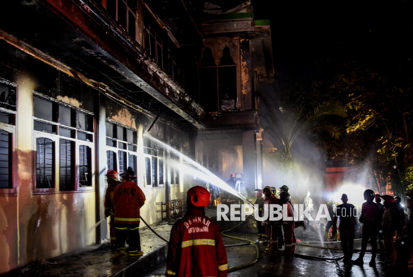 Sejumlah petugas pemadam kebakaran melakukan pembasahan saat terjadinya kebakaran di pondok Pesantren Nabil Husein di Samarinda, Kalimantan Timur, Rabu (12/3/2025). Menurut petugas Dinas Pemadam Kebakaran Kota Samarinda, kebakaran diduga akibat hubungan pendek listrik pada lantai tiga gedung ruang guru dari pondok pesantren itu dan tidak ada korban jiwa. 