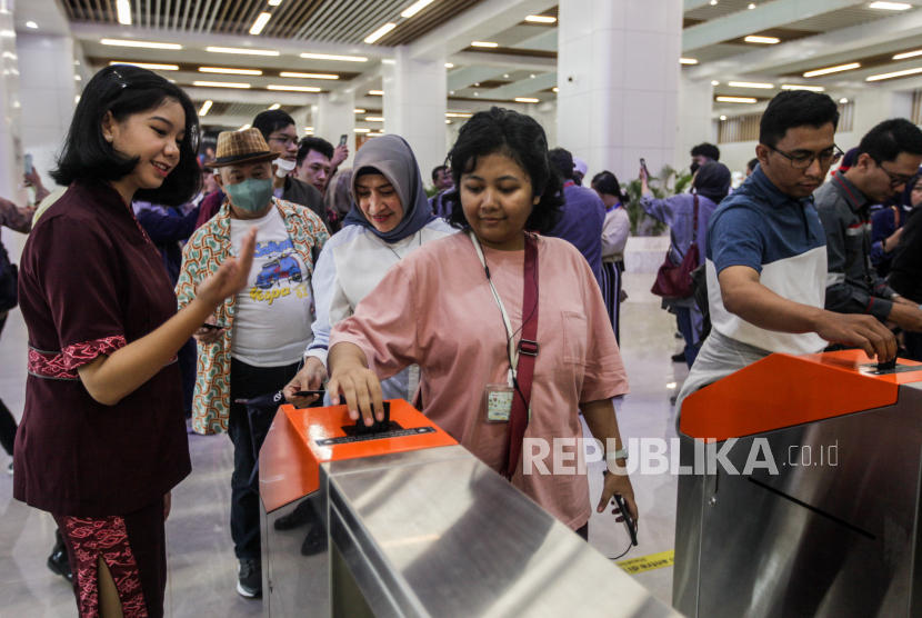 Pramugari membantu penumpang yang akan menaiki Kereta Cepat Jakarta Bandung di Stasiun Halim, Jakarta, Selasa (3/10/2023). Kereta Cepat Jakarta Bandung atau Whoosh telah beroperasi untuk penumpang umum mulai hari ini tanpa dikenakan tarif hingga pertengahan Oktober 2023.