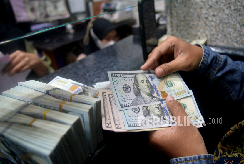 Warga menghitung uang di salah satu gerai penukaran uang asing di Jakarta, Rabu (6/5/2020). 