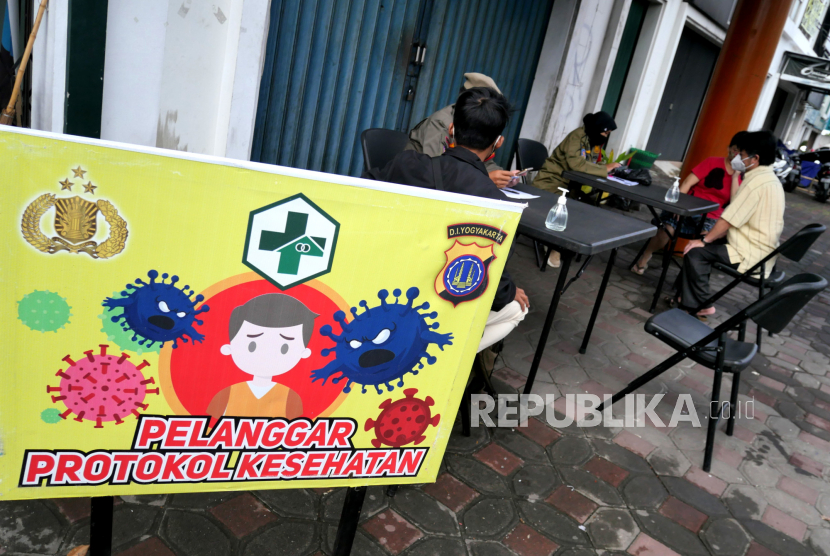 Satpol PP memberikan penyuluhan kepada pelanggar operasi yustisi razia masker di Jalan Lingkar Utara Yogyakarta, Rabu (30/12). Pemerintah pusat kembali memberlakukan pembatasan aktivitas masyarakat pada 11-25 Januari 2021 untuk menekan angka penularan Covid-19. 