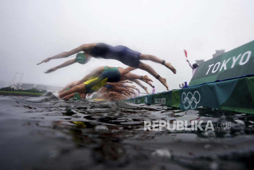 Para peserta terjun ke dalam air untuk memulai triathlon individu putri di Olimpiade Musim Panas 2020, Selasa, 27 Juli 2021, di Tokyo.