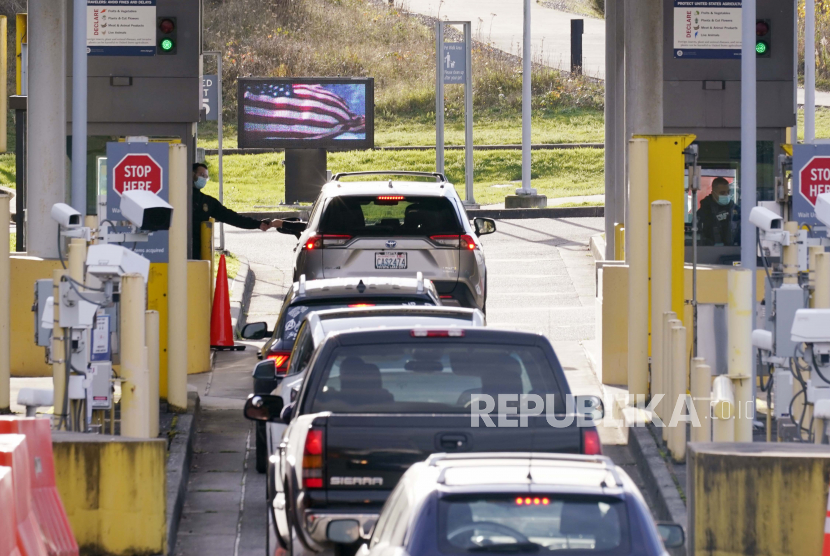  Mobil berbaris untuk memasuki AS dari Kanada di perbatasan Peace Arch Senin, 8 November 2021, di Blaine, Washington. AS membuka kembali perbatasan daratnya untuk perjalanan yang tidak penting Senin setelah hampir 20 bulan pembatasan COVID-19. 