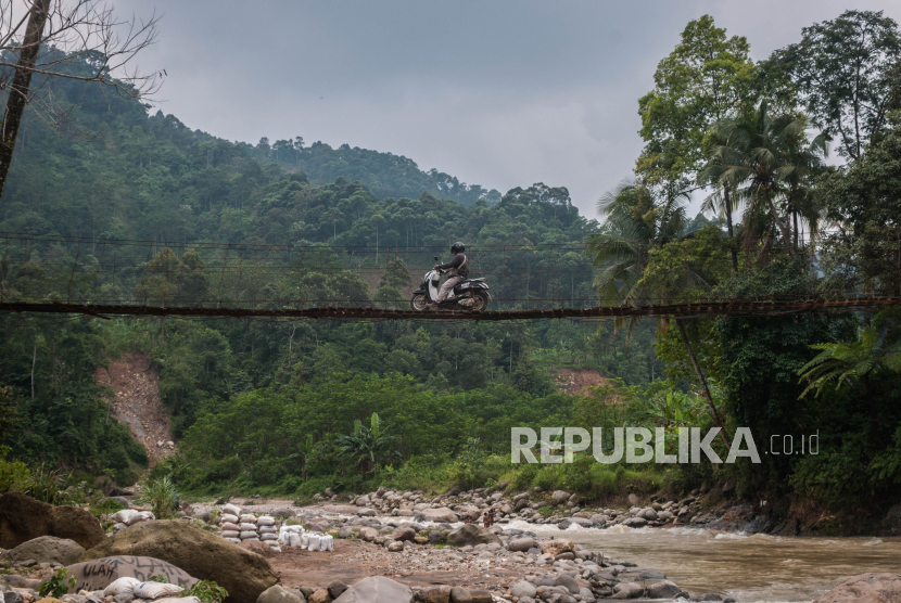 Warga menggunakan kendaraan roda dua menyebrangI jembatan gantung. (Ilustrasi)