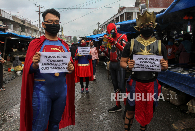 Petugas Dinas Kominfo Provinsi Riau mengenakan kostum superhero  melakukan sosialisasi pencegahan penularan COVID-19 di salah satu pasar tradisional di Pekanbaru, Riau, Kamis (23/4/2020). Kegiatan sosialisasi sekaligus pembagian masker dilakukan guna memberikan informasi terkait cara pencegahan COVID-19
